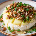 A delicious Pineapple Cheese Ball coated with nuts and garnished with chives, served with crackers.