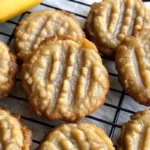 Two golden-brown banana bread cookies cooling on a rack