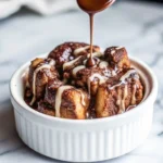 Slice of decadent bourbon-soaked brioche pudding drizzled with bourbon sauce