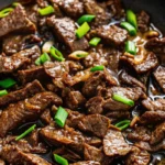 Ginger soy flank steak garnished with scallions