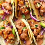 Crispy Cauliflower Tacos topped with slaw and lime cilantro crema