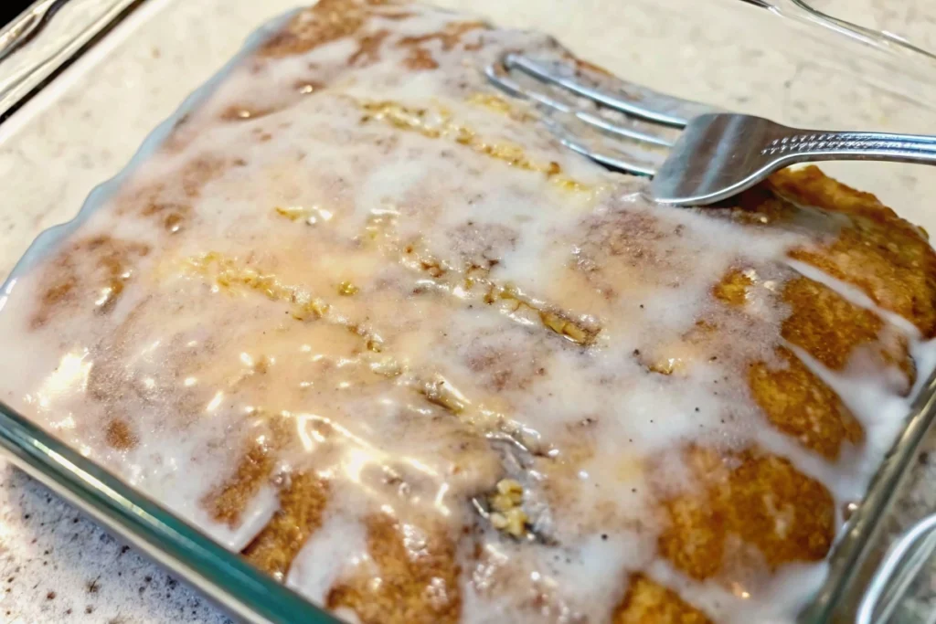 Slice of Honey Bun Cake with cinnamon‑sugar swirl and glaze