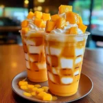 Mango and White Cream Frappuccino topped with whipped cream and mango slices