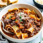 Plate of pappardelle topped with rich short rib ragu and fresh parsley