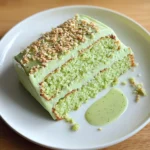 Slice of green lime cake with glossy lime glaze and fresh lime zest
