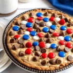 Warm slice of gooey chocolate chip cookie pie in a buttery pie crust