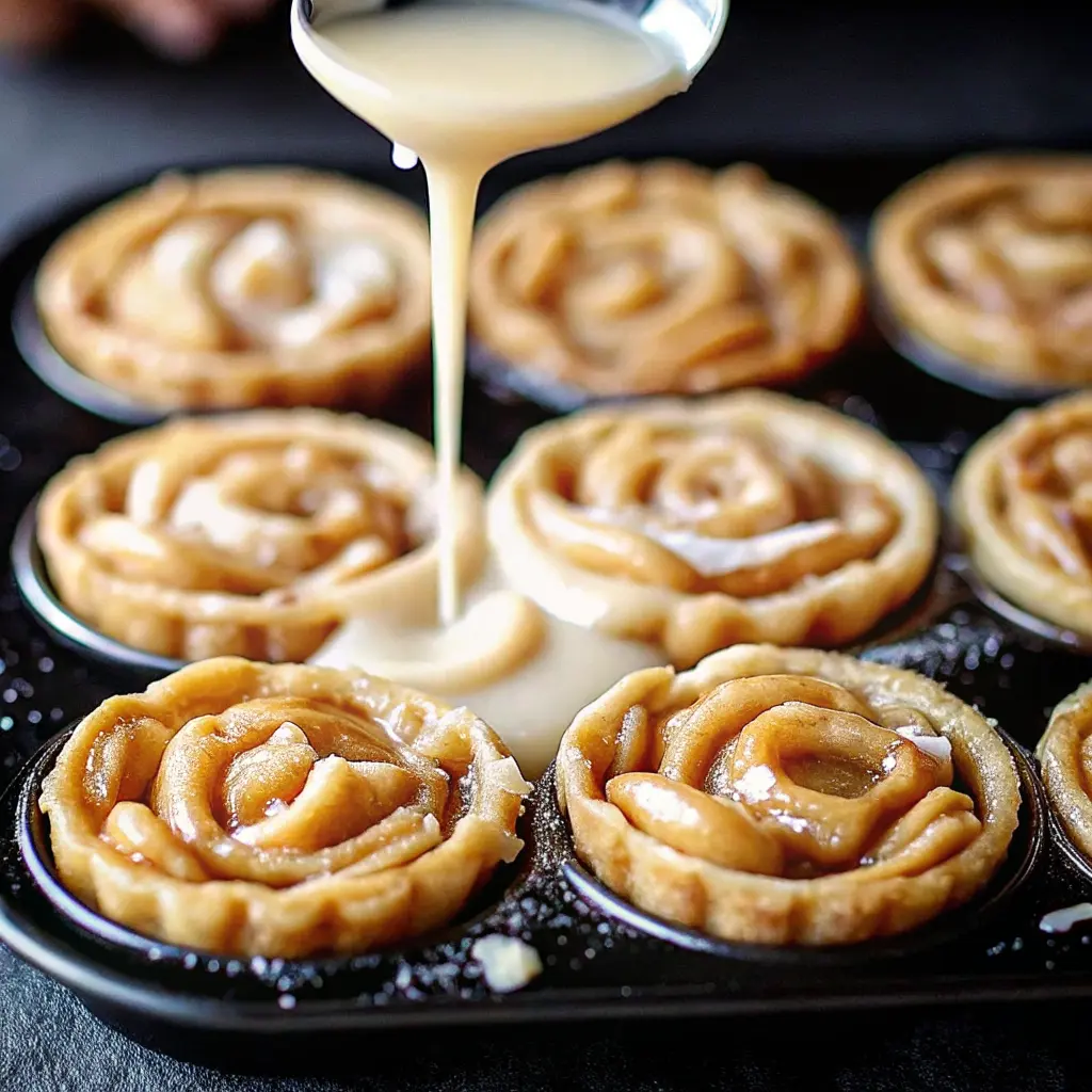 Grilled apple pie cinnamon roll cups in muffin tin with caramelized edges