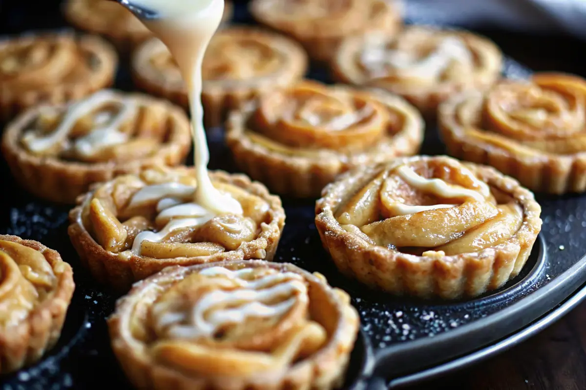 Grilled apple pie cinnamon roll cups in muffin tin with caramelized edges