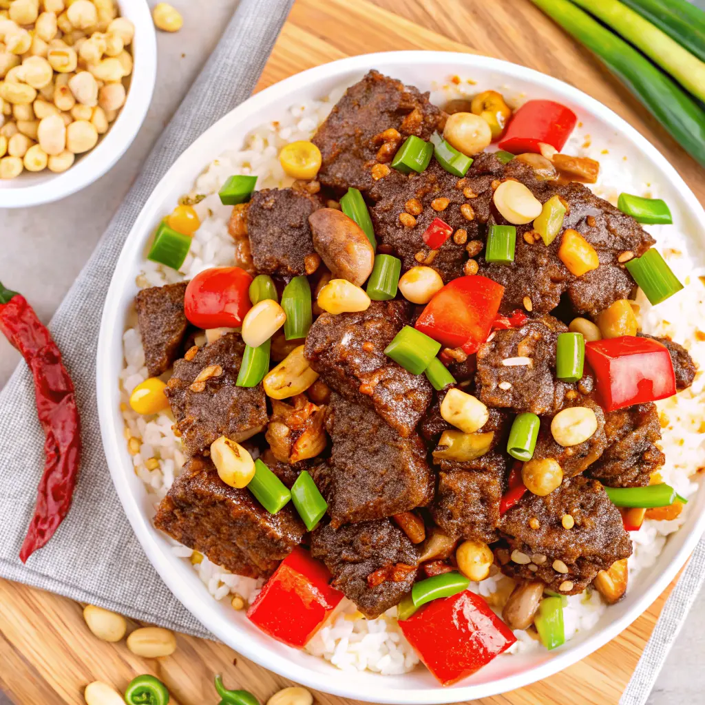 Kung Pao Beef stir-fry with spicy chilies, tender beef strips, and crunchy peanuts served in a wok