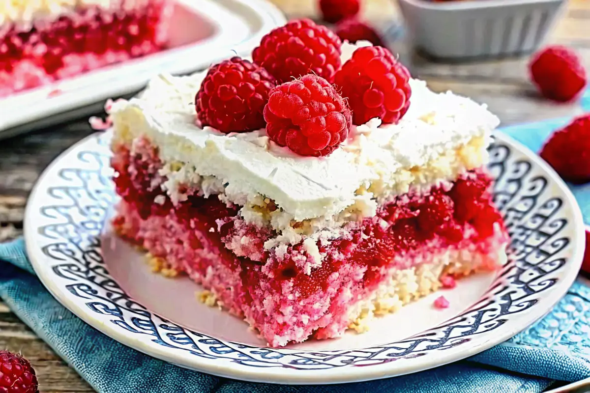 Moist Raspberry Zinger Poke Cake topped with creamy whipped layer and pink coconut