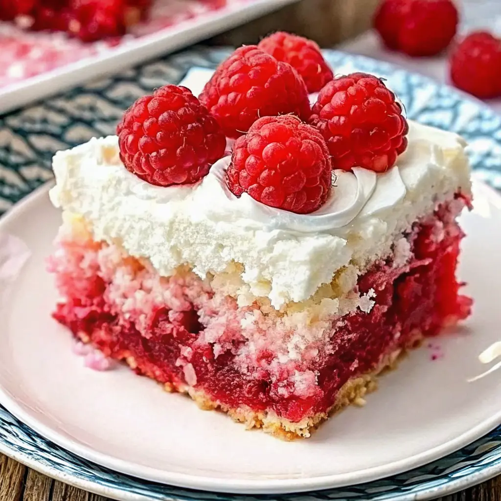 Moist Raspberry Zinger Poke Cake topped with creamy whipped layer and pink coconut