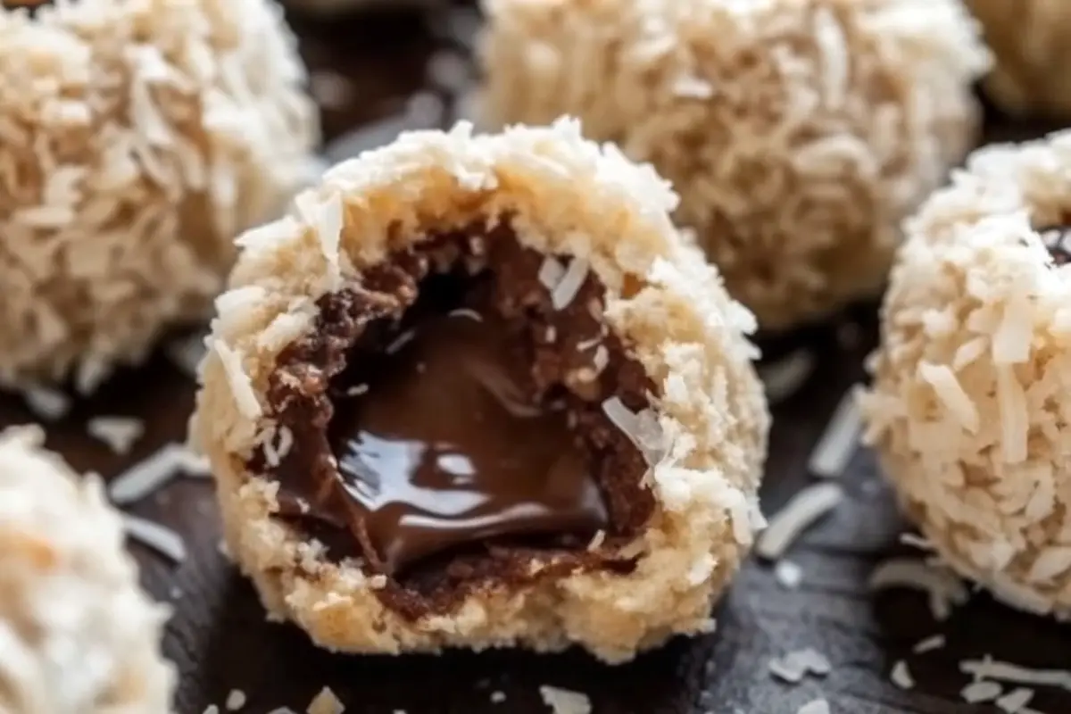 Chocolate Coconut Bliss Balls with a Creamy Chocolate Center rolled in coconut and cocoa on a dessert tray