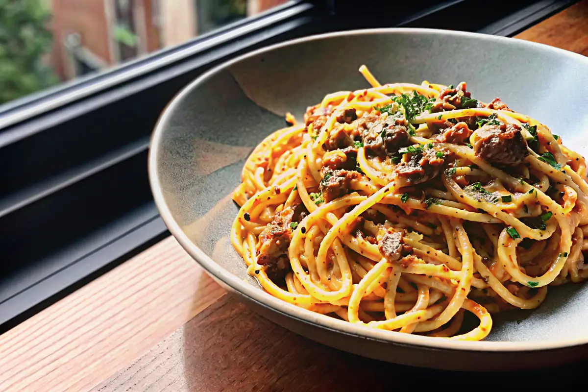 Bowl of creamy beef garlic butter pasta with Parmesan and parsley garnish