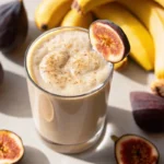 Glass of fig smoothie Recipe topped with fresh fig slices and sprinkled cinnamon