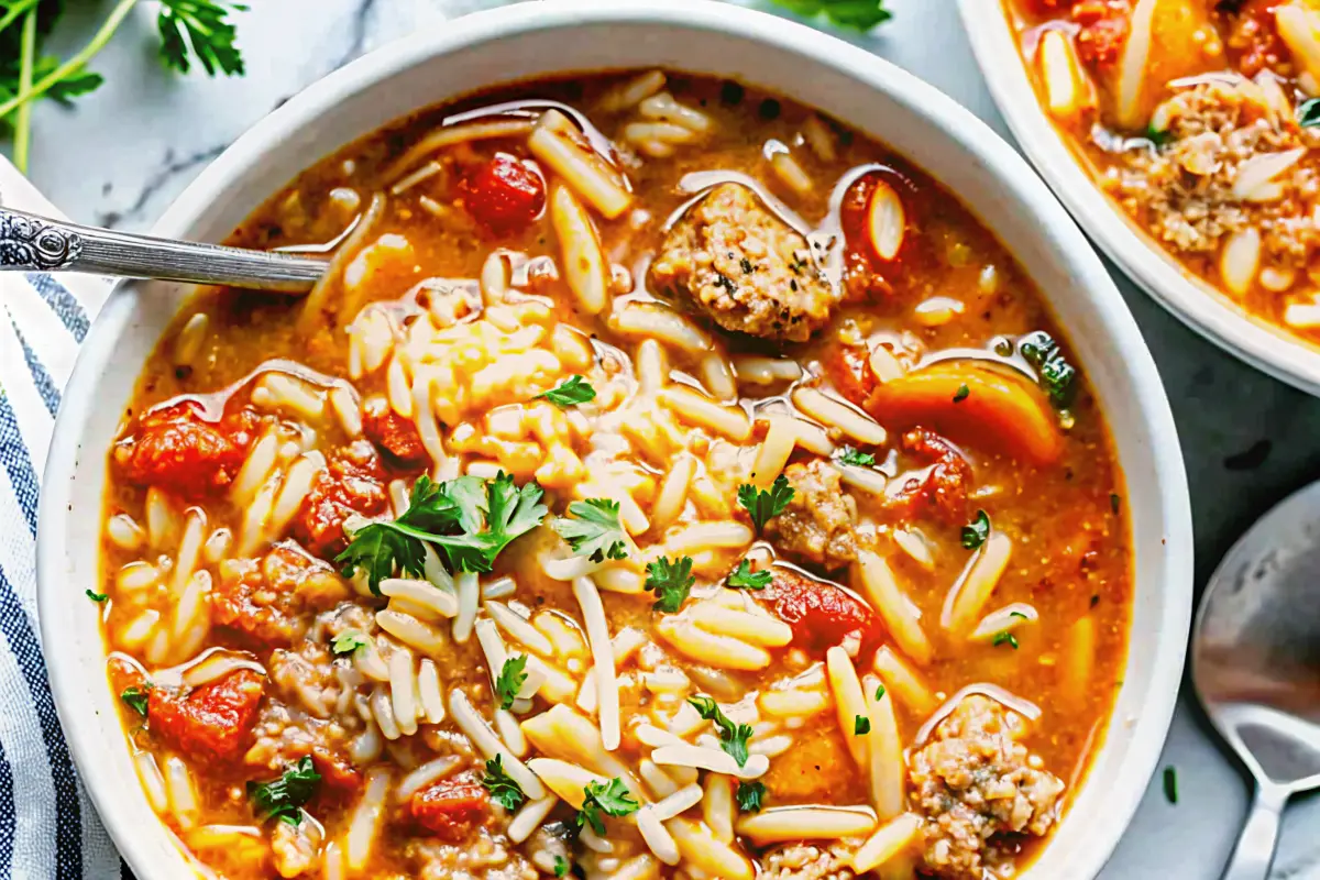 Bowl of One-Pot Italian Sausage Orzo Soup with fresh herbs