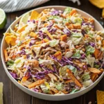 Frito Cowboy Cabbage Salad Recipe in a bowl topped with Fritos, peppers, black beans, and cilantro.