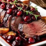 Tender balsamic cranberry beef roast recipe sliced on a platter with glossy cranberry balsamic sauce
