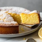 Gooey lemon butter cake squares dusted with powdered sugar