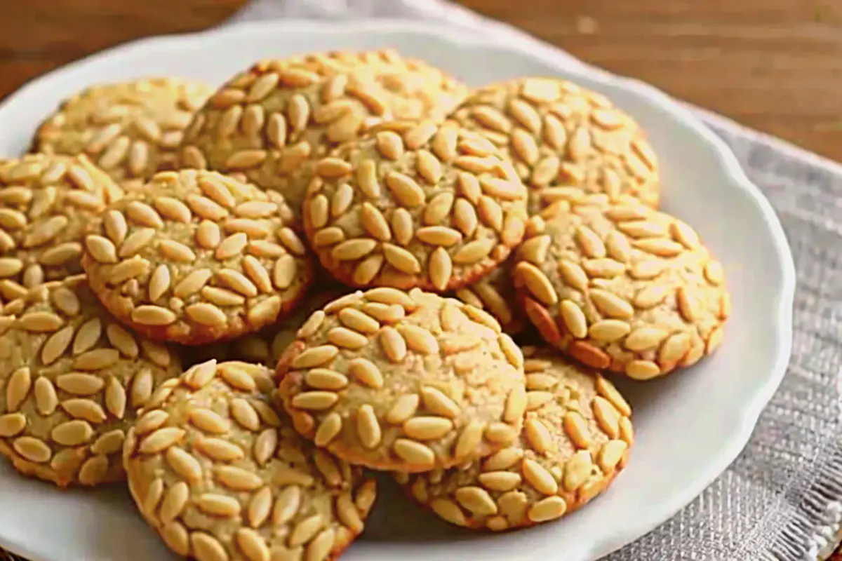 Pignoli Cookies coated in pine nuts on a baking tray