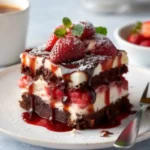 Decadent chocolate strawberry cheesecake slice topped with ganache and fresh strawberries