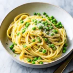Creamy lemon pasta with peas served in a bowl