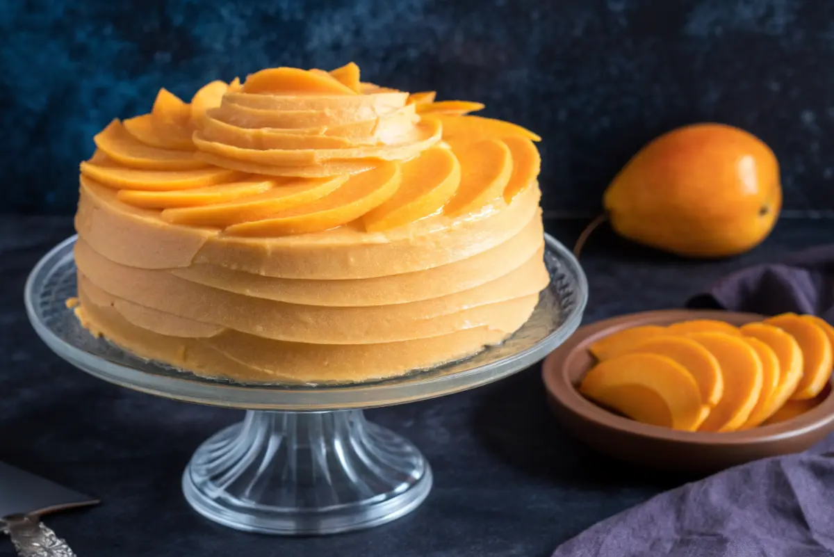 eggless mango cake recipe sliced with fresh mango topping