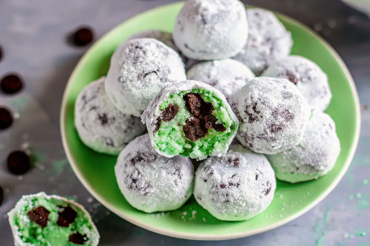 Minty chocolate snowball bites coated in powdered sugar on a festive plate