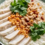 Chicken rice porridge recipe in a bowl with green onions and crispy toppings
