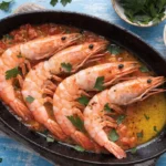 Prawns alla Busara recipe served in a skillet with garlic tomato sauce and parsley
