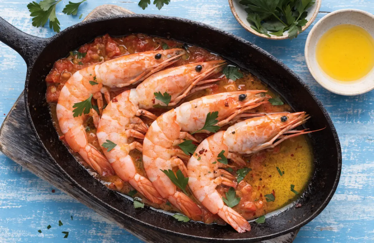 Prawns alla Busara recipe served in a skillet with garlic tomato sauce and parsley