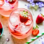 Strawberry Rose Gin Fizz cocktail with fresh strawberries and rose petals
