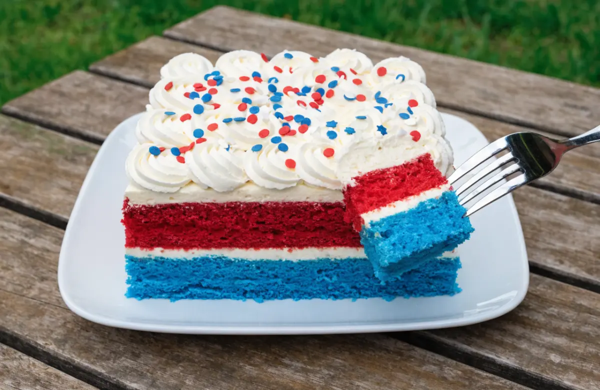 Patriotic poke cake topped with whipped cream, strawberries, and blueberries