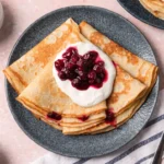 Authentic Swedish pancakes recipe served with lingonberry jam and fresh berries