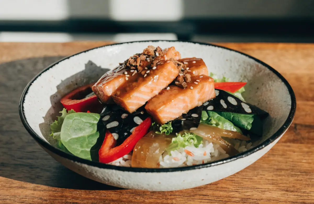 Spicy Chipotle Honey Salmon Rice Salad served with fresh vegetables and lime